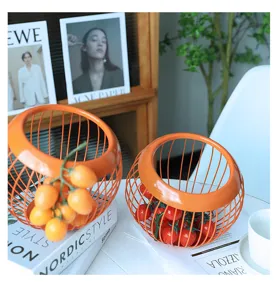 Cesto portafrutta in filo metallico arancione moderno, design inclinato elegante per casa.