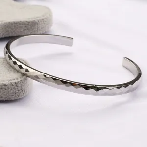 Vue détaillée du bracelet jonc ouvert en métal facetté avec une belle finition pour hommes.