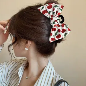 Detail view of a cute cherry print bow hair claw clip, perfect for stylish daily hairstyles.