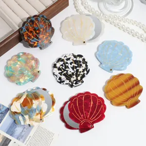 Detailed shot of portable shell folding makeup mirror with various colorful acrylic patterns.