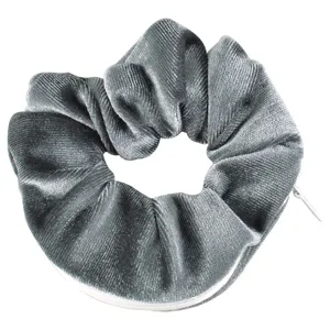Close-up of grey velvet scrunchie featuring a hidden zipper pocket for small storage.