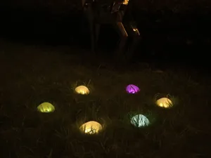 Close-up van gloeiende stenen tuinverlichting die 's nachts gras verlicht, detail.