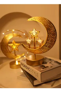 Detailed view of golden iron art moon and star led lamp, warm glowing tabletop decor for room.