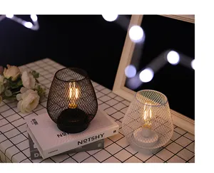 Close-up detail van creatieve ijzeren gaas LED tafellamp, warme verlichting voor gezellige kamer.
