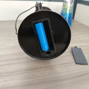 Detailansicht des Batteriefachs der tragbaren Campinglaterne mit blauem Akku im Inneren.