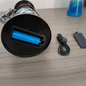 Detailansicht der wiederaufladbaren Vintage-Campinglaterne mit Batteriefach und Ladekabel.