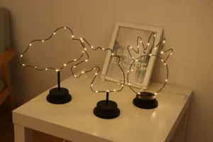 Vista detallada de la lámpara de mesa decorativa creativa de arte de hierro LED con luces de cadena.