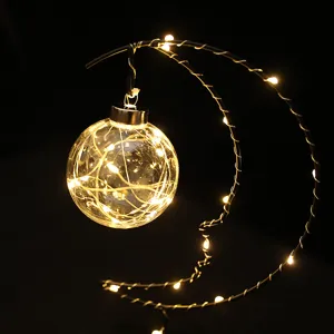 Moon shaped LED night light with hanging glowing glass ball for warm bedroom holiday home decor.