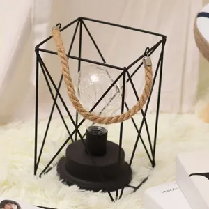 Linterna moderna de alambre de metal geométrico con asa de cuerda de cáñamo y bombilla.