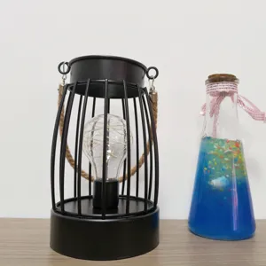 Minimalistische zwarte metalen kooi tafellamp met touw handvat en LED lichtjes voor decor.
