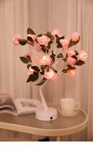 Detailopname van romantische rozenboomlamp met gloeiende roze bloemen voor gezellige kamerinrichting.