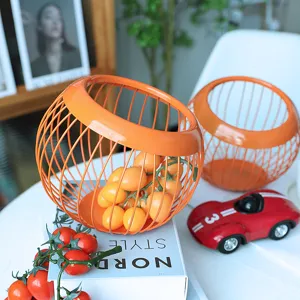 Cesto portafrutta in filo metallico arancione nordico minimalista per soggiorno tavolino.