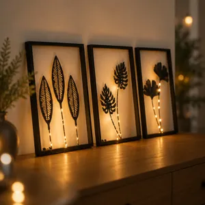 Set di tre decorazioni da parete in metallo nero con foglie e luci LED calde per interni.