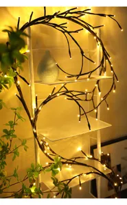 Detailopname van decoratieve tak-LED-lichtsnoeren met een warmgele gloed op de plank.