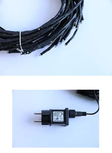 LED-lichtsnoer detailweergave met omwikkelde zwarte takken en voedingsadapter met label