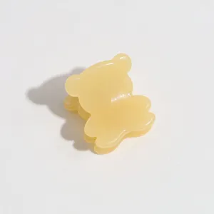 Yellow bear hair claw clip close-up, cute mini hair accessory for side bangs styling.
