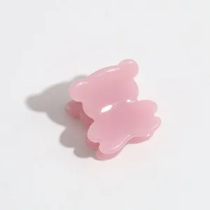 Close-up detail shot of a cute pink mini bear claw clip showing translucent resin texture.