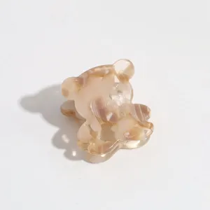 Close-up detail of cute mini bear hair claw clip, aesthetic beige acrylic hair accessory for bang.