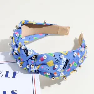 Serre-tête noué bleu avec perles et imprimé école, accessoire de mode pour les détails.