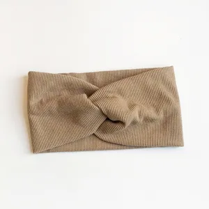 Vue détaillée du bandeau torsadé en tricot côtelé doux de couleur kaki, montrant la texture.