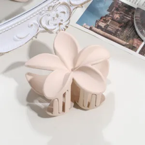 Matte frangipani hair claw clip, large cream flower shark clip for women styling hair.