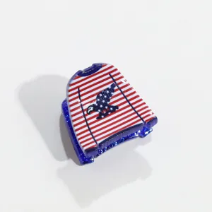 Gros plan détaillé de la pince à cheveux patriotique rouge, blanche et bleue avec motif d'aigle.