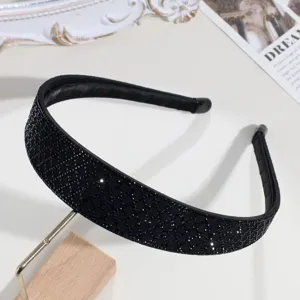 Gros-plan bandeau large à strass noirs, détail de cerf-tête en cristal scintillant.
