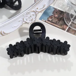 Close-up detail of black matte floral hair claw clip, elegant daily hair styling accessory.
