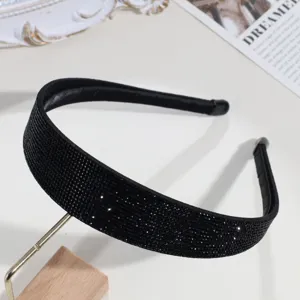 Gros plan détaillé d'un serre-tête large en strass noir étincelant, accessoire de cheveux chic.