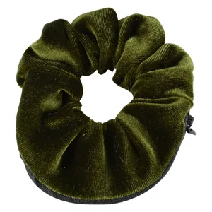 Detailed view of the dark green velvet scrunchie featuring a hidden zipper pocket design.
