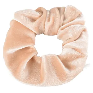 Detailed close-up of a soft velvet hair scrunchie in light pink, perfect for daily styles.