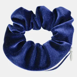 Close-up detail of dark blue velvet hair scrunchie with hidden zipper pocket design.