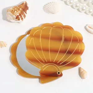 Close up view of the marine style shell folding pocket makeup mirror with detailed textures.