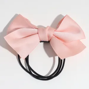Chouchou nœud papillon en satin rose avec élastiques noirs pour queue de cheval.