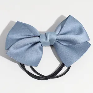 Chouchou queue de cheval noeud papillon en satin gris-bleu, détail design élégant.