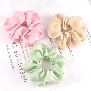 Detalle de coleteros de terciopelo, gomas para el pelo rosas, beiges y verdes para peinados.