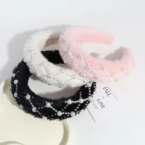 Detailaufnahme von trendigen Plüsch Perlen Haarreifen in Schwarz, Weiß und Pink für Damen.