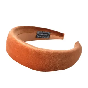Detailed view of the brown velvet padded headband showcasing soft fabric texture and inner label.