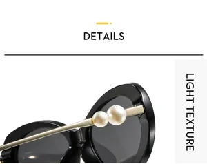 Detail view of stylish black oval sunglasses with elegant pearl and gold temple decorations.