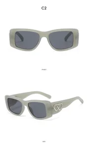 Detailed view of grey cat-eye sunglasses with dual heart rhinestone temple charms.