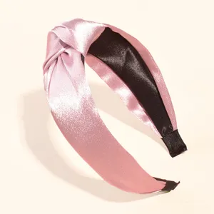 Detailansicht eines rosa Satin Haarreifs mit Knoten, elegant und bequem für den Alltag.