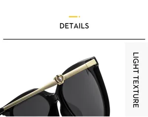Close-up detail of luxury black cat-eye sunglasses with elegant gold heart pearl temples.