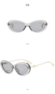 Close-up detail of vintage oval sunglasses with stylish pearl accent temples and grey lenses.