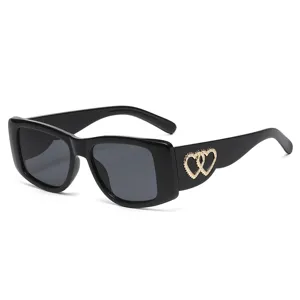 Fashion retro black cat-eye sunglasses with gold heart detail for women outdoor street style.