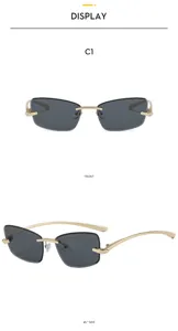 Vue de détail de lunettes de soleil carrées et sans monture élégantes avec une monture dorée.