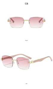 Detalle de gafas de sol rosas sin montura con bisagras doradas y patillas elegantes.
