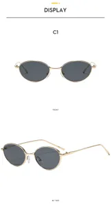 Occhiali da sole ovali retro in metallo dorato e lenti scure, vista dettagli donna.
