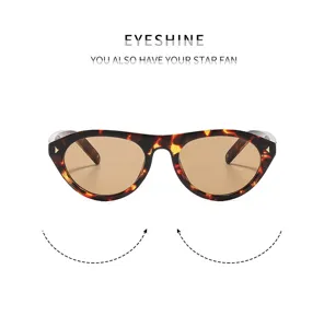 Détail de lunettes de soleil œil-de-chat écaille, verres marron, rivets métalliques, style rétro.