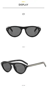 Vue détaillée de lunettes de soleil œil-de-chat vintage noires avec bande et rivets en métal.