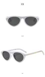 Detail de lunettes de soleil cat-eye ovales blanches avec des accents de rivets dores.